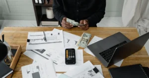 Propietario de un restaurante revisando reportes financieros y calculando los ingresos del negocio.